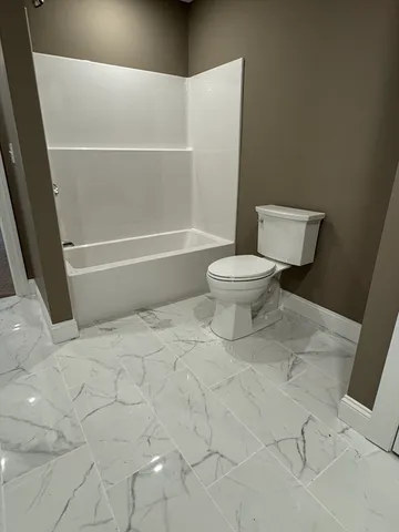 a bathroom with a toilet and a shower