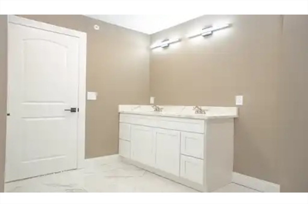 63 Progressive Street Worcester, MA 01604 - Photo 15 of 22 a bathroom with a granite countertop sink a mirror and a vanity