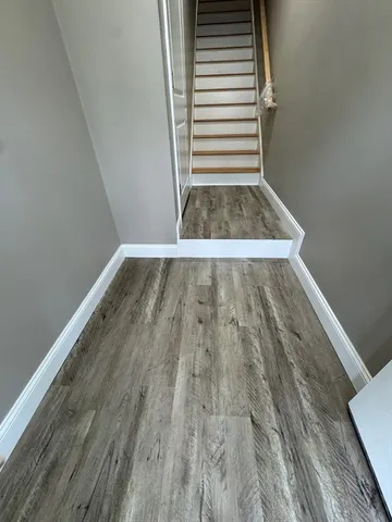 a view of a room with wooden floor and white walls