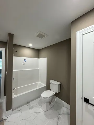 a bathroom with a toilet and a shower