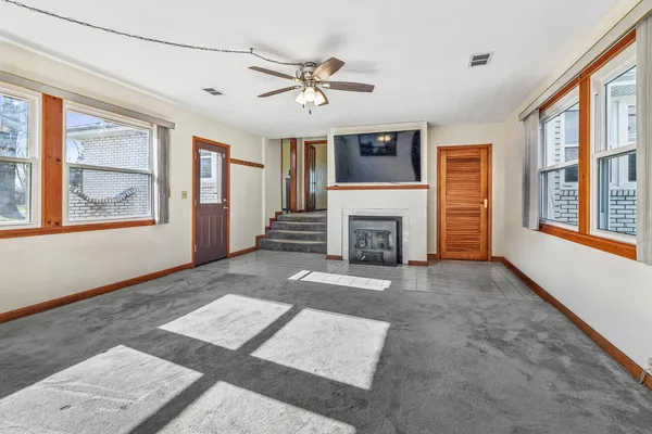 a view of an empty room with a fireplace and a window