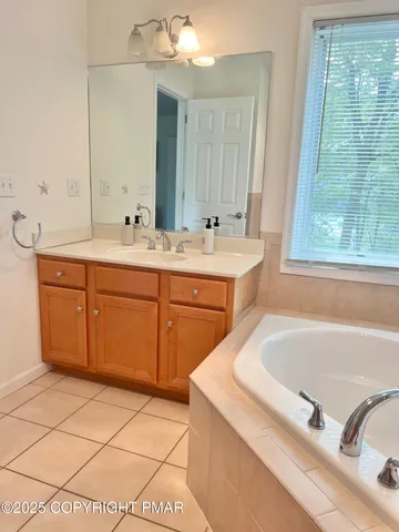 a bathroom with a tub sink and mirror
