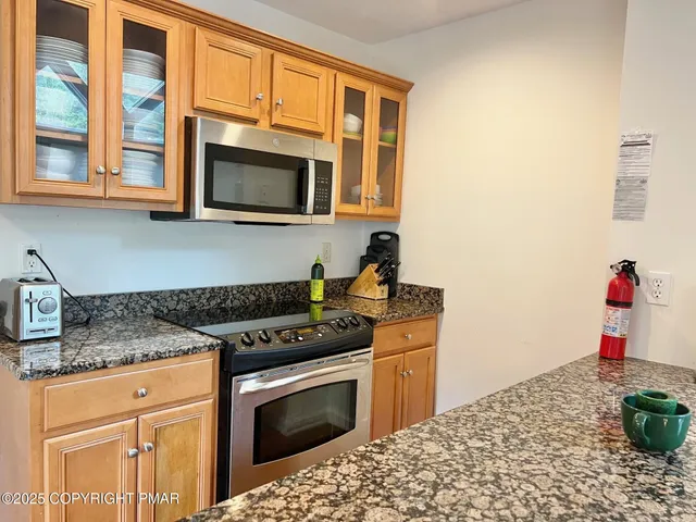 a kitchen with stainless steel appliances granite countertop a stove and a microwave