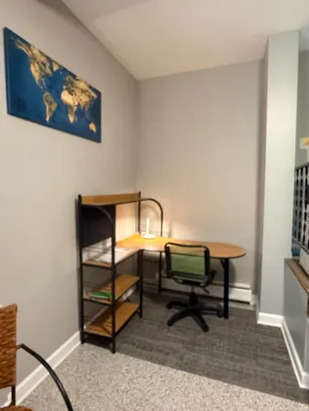 a bedroom with a bed and a lamp on dresser