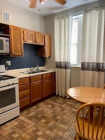 a kitchen with stainless steel appliances a stove a sink cabinets and a dining table