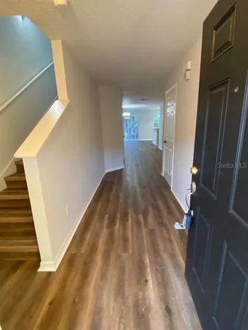 a view of a hallway with wooden floor and staircase