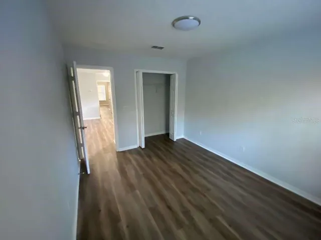 a view of empty room with wooden floor