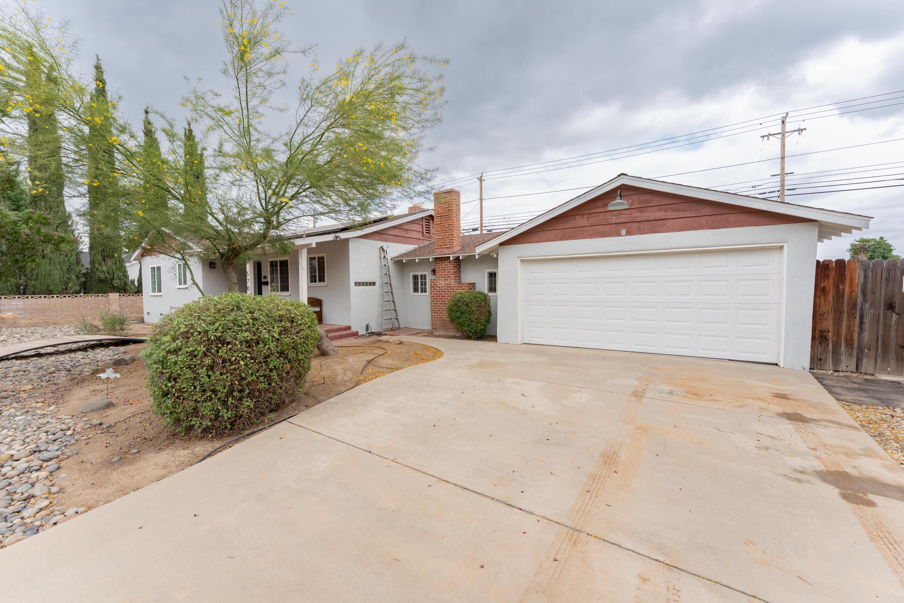 570 North Birch Avenue Reedley, CA 93654 - Photo 9 of 52 a front view of a house with a yard and garage