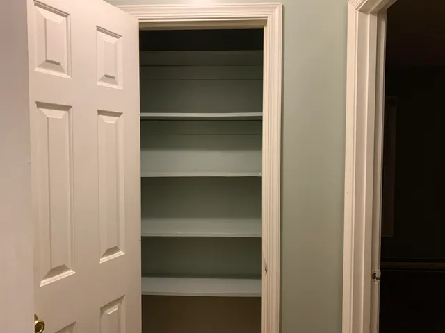 a view of a small space with wooden floor and a window