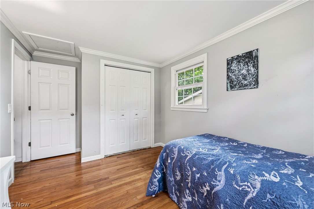 6472 Southgrove Road Mentor, OH 44060 - Photo 22 of 37 Bedroom featuring wood-finish flooring, white trim, and a double bi-fold closet
