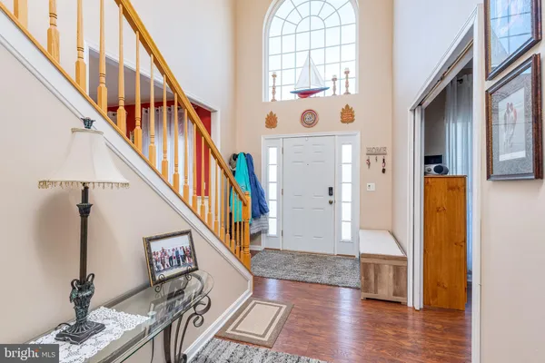 a view of staircase with lots of frames on wall and wooden floor