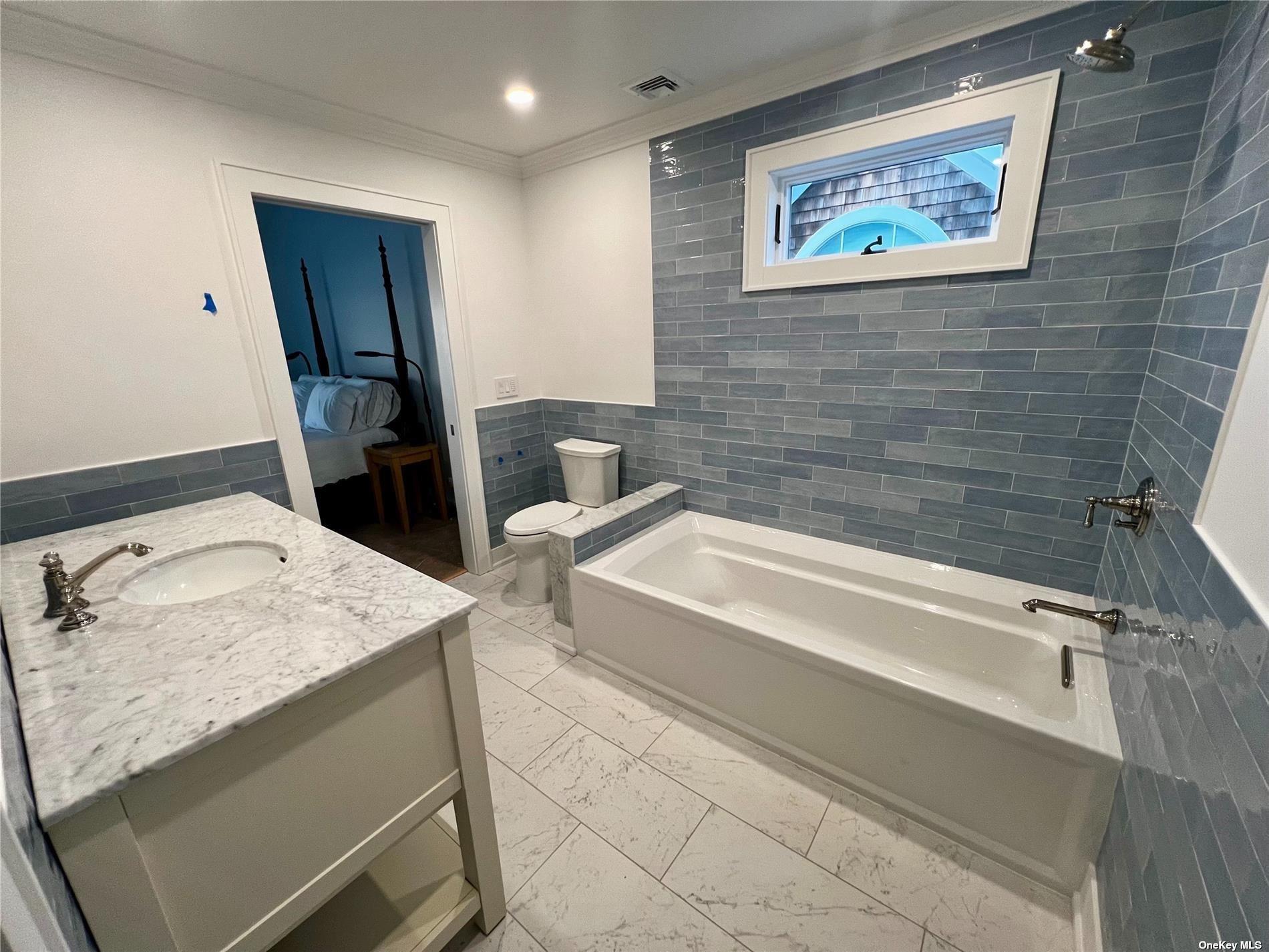 23 A Oakhurst Road Hampton Bays, NY 11946 - Photo 13 of 16 a bathroom with a sink and a bathtub