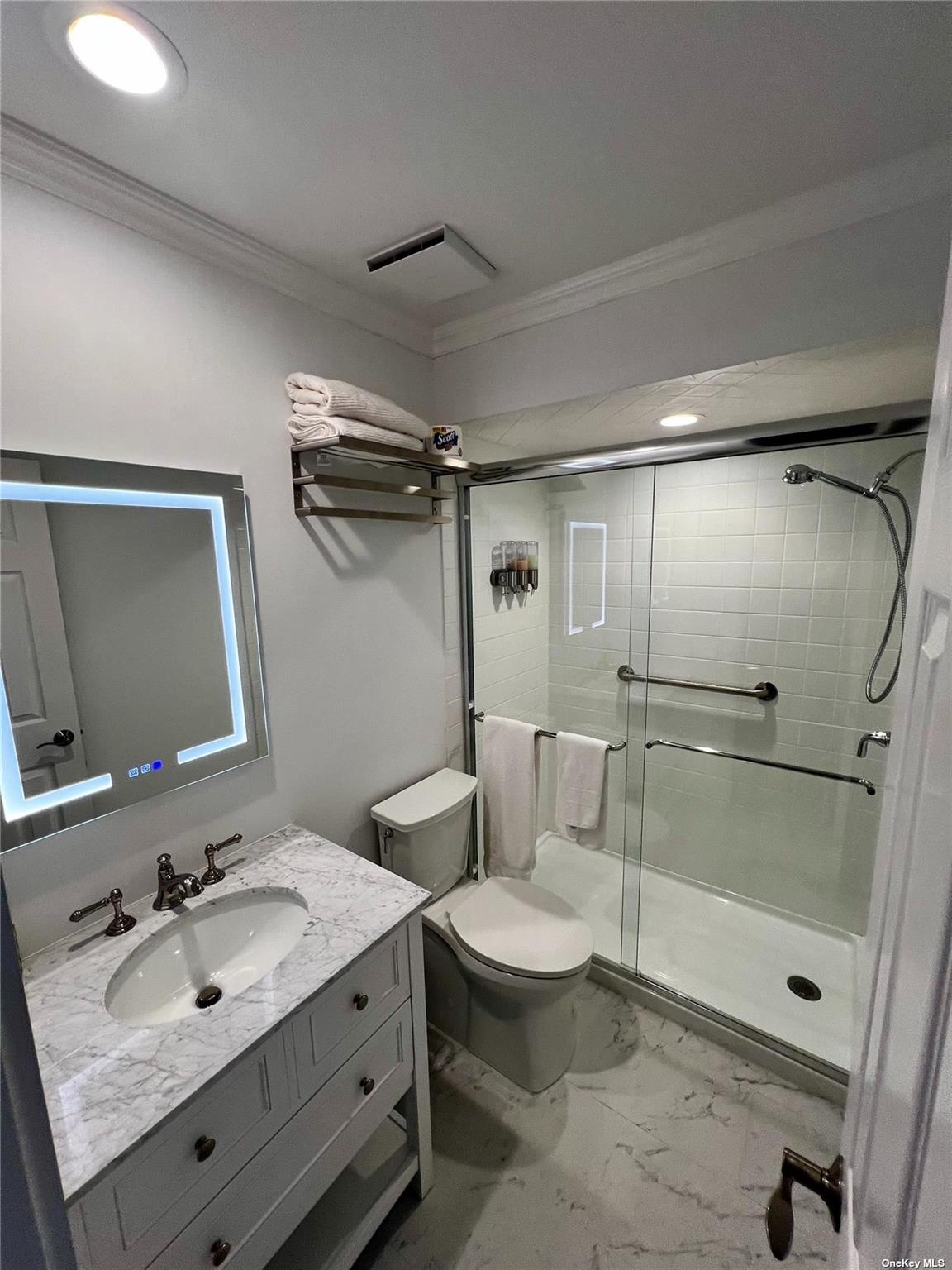 23 A Oakhurst Road Hampton Bays, NY 11946 - Photo 15 of 16 a bathroom with a sink mirror toilet and shower