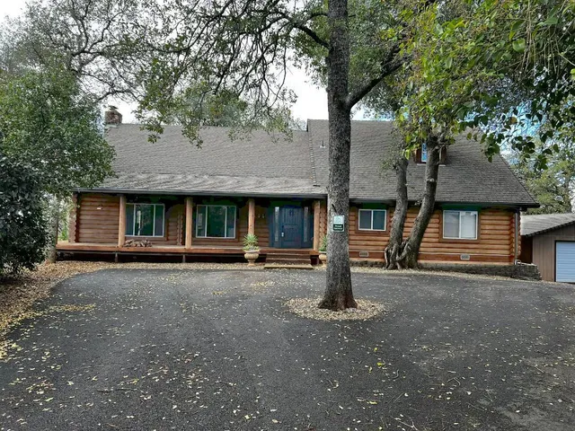 a front view of a house with a tree