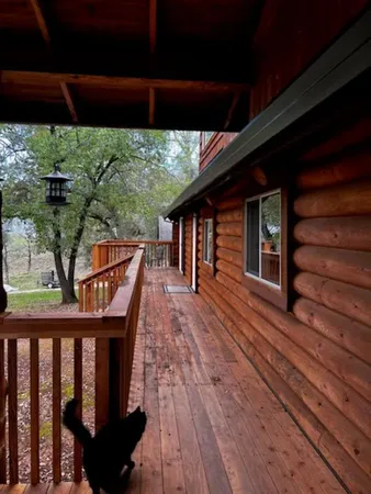 a balcony with wooden floor outdoor seating and yard in back