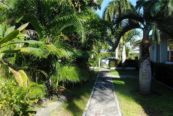 a front view of a house with a yard and potted plants