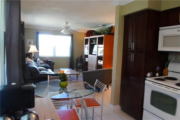 a living room with furniture a flat screen tv and kitchen view