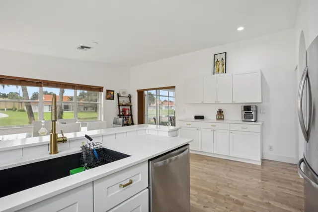 a kitchen with white cabinets and a window