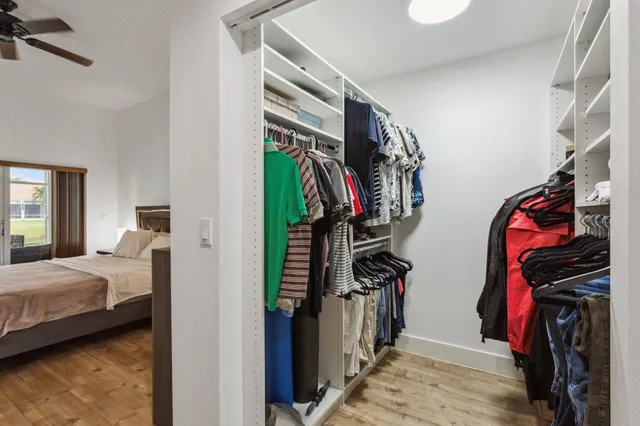 a view of walk in closet with clothes and shoes