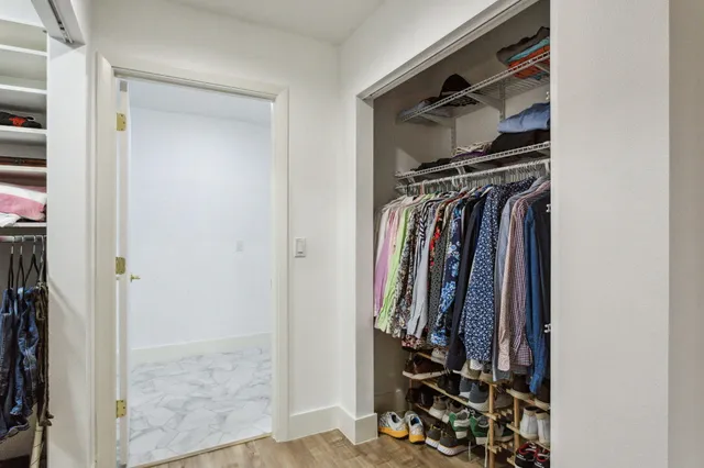 a view of walk in closet with clothes and shoes