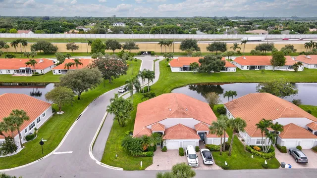 an aerial view of a house with outdoor space lake view and large trees