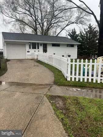 a view of a white house with a yard and potted plants