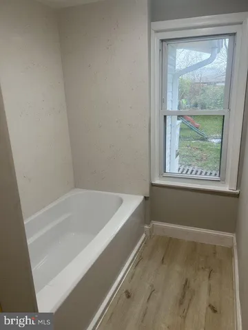 a bathroom with bathtub and window