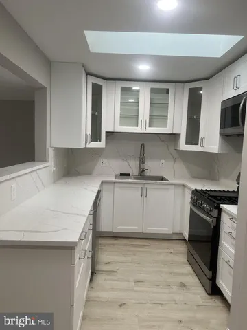 a kitchen with stainless steel appliances granite countertop a sink and a stove top oven