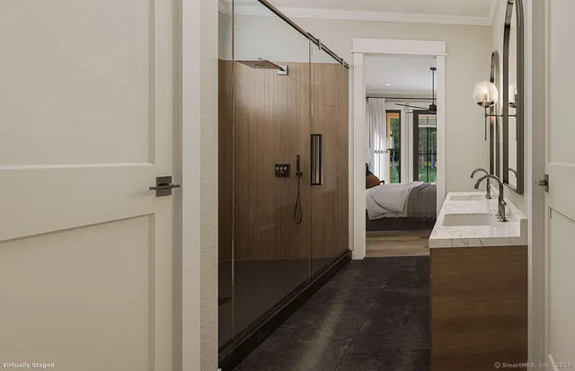 a bedroom with a bed mirror and a hardwood