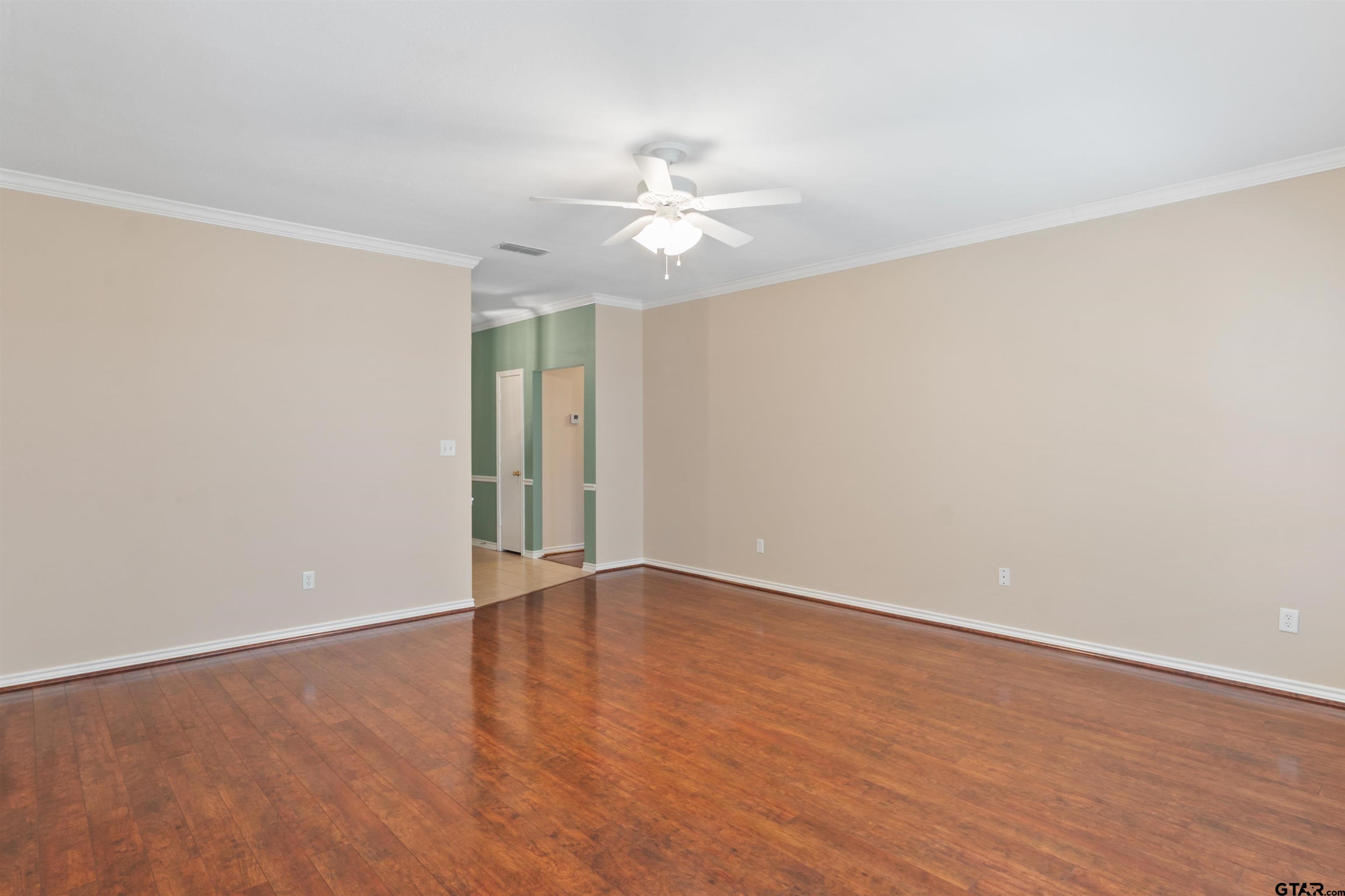 1521 Rice Road, Unit G102 Tyler, TX 75703 - Photo 6 of 23 an empty room with wooden floor fan and window
