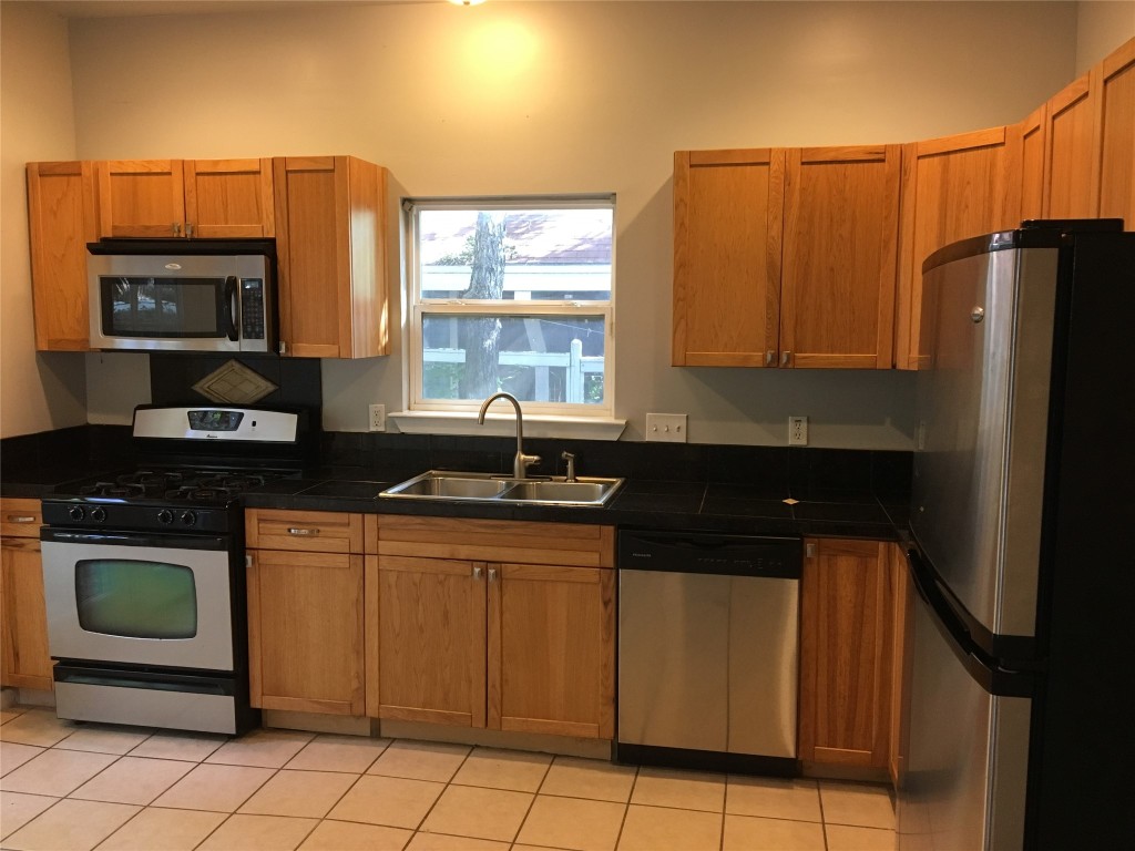 4802 Clarkson Avenue Austin, TX 78751 - Photo 12 of 38 a kitchen with stainless steel appliances a sink stove and refrigerator