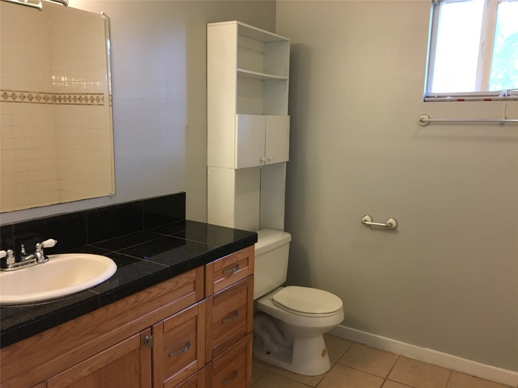 4802 Clarkson Avenue Austin, TX 78751 - Photo 31 of 38 a bathroom with a granite countertop sink toilet and mirror