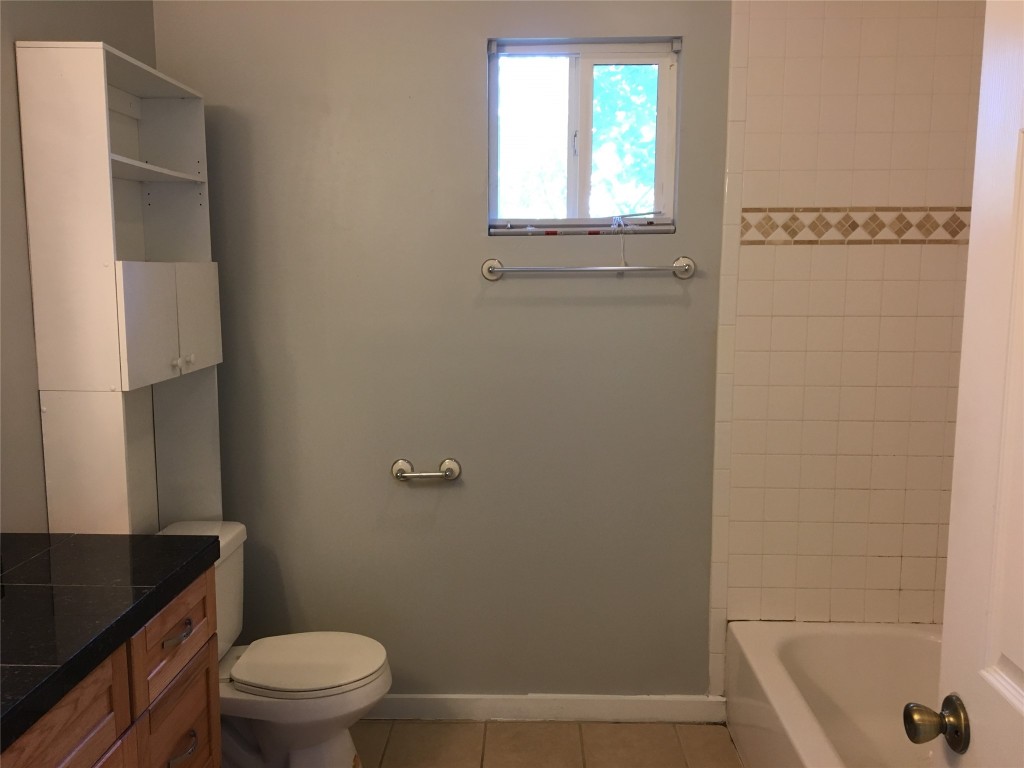 4802 Clarkson Avenue Austin, TX 78751 - Photo 32 of 38 a bathroom with a granite countertop toilet a sink and a bathtub