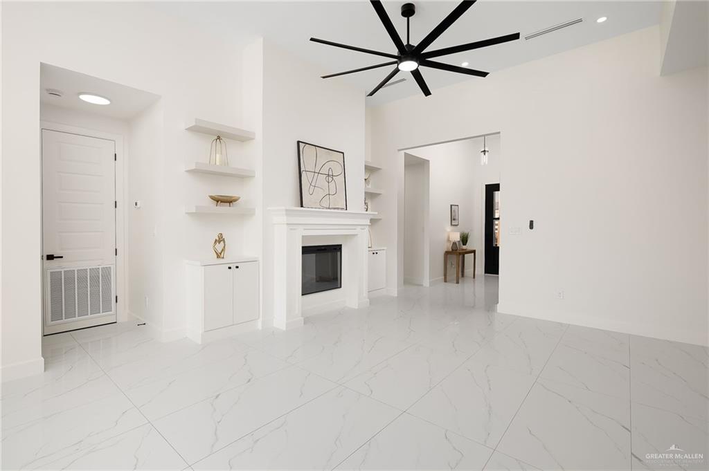 901 Azalea Street Mission, TX 78573 - Photo 11 of 29 Living room featuring a glass covered fireplace, ceiling fan, recessed lighting, and built in features