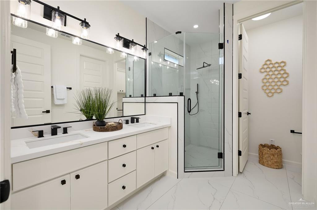 901 Azalea Street Mission, TX 78573 - Photo 16 of 29 Full bath featuring a porcelain finish shower, double vanity, and light marble finish flooring