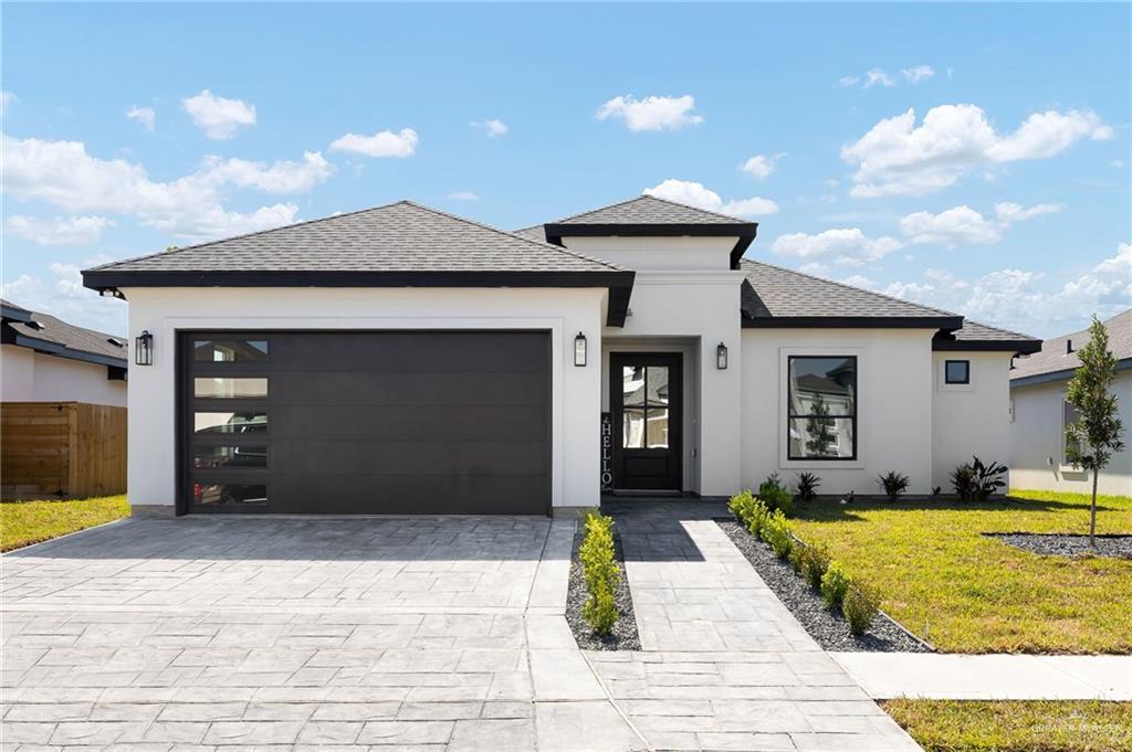 901 Azalea Street Mission, TX 78573 - Photo 27 of 29 Prairie-style house featuring roof with shingles, stamped driveway, and stucco siding