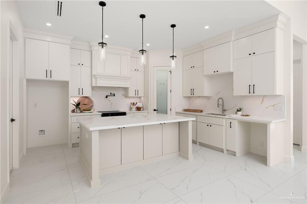 901 Azalea Street Mission, TX 78573 - Photo 8 of 29 Kitchen featuring light Quartz countertops, light cabinetry, pendant lighting, and a 7' kitchen island