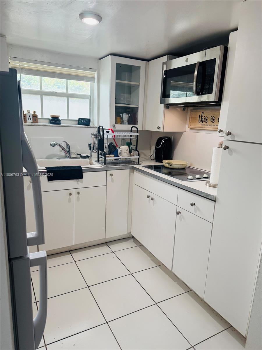 3915 Northwest 4th Terrace Miami, FL 33126 - Photo 42 of 42 a kitchen with a sink a stove and cabinets