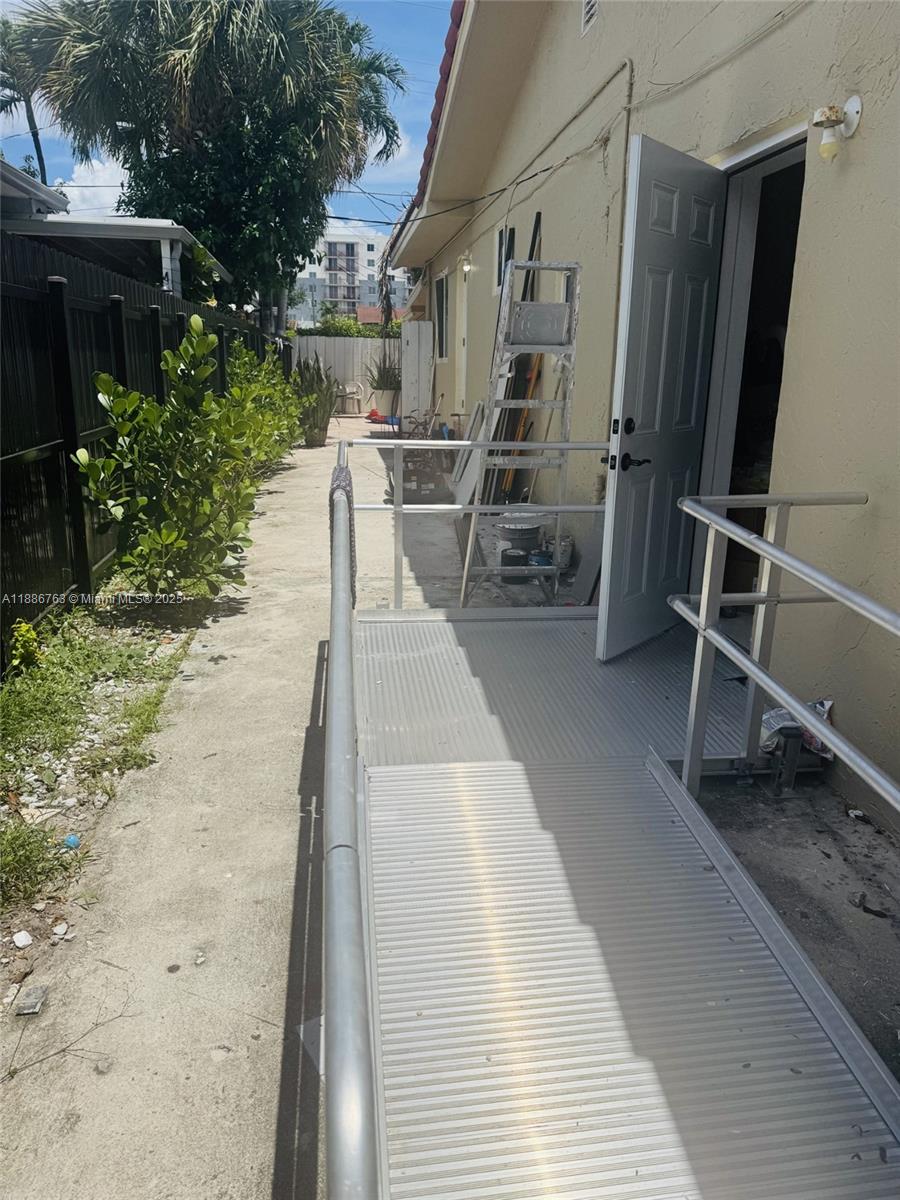 3915 Northwest 4th Terrace Miami, FL 33126 - Photo 8 of 42 a view of a patio with table and chairs a barbeque with wooden floor and fence
