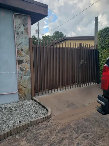 a view of a backyard with floor to ceiling window and wooden fence
