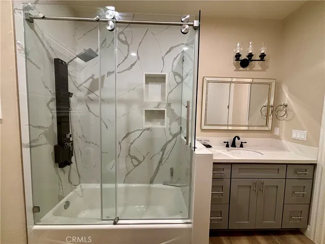 a bathroom with a shower a mirror and a sink