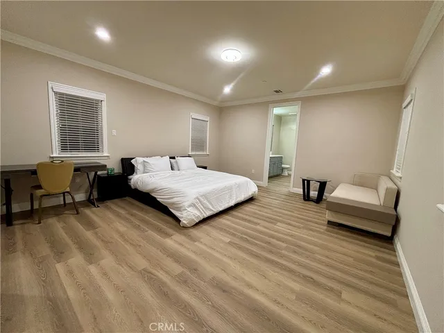 a spacious bedroom with a bed a couch and dresser