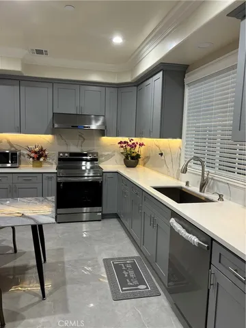 a kitchen with stainless steel appliances a sink stove and cabinets