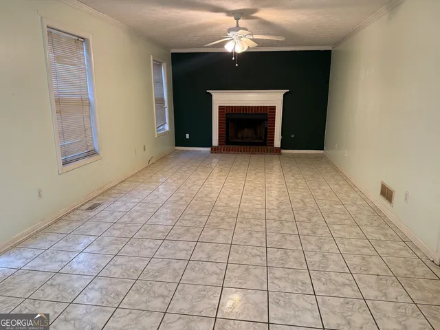 an empty room with windows and a fireplace