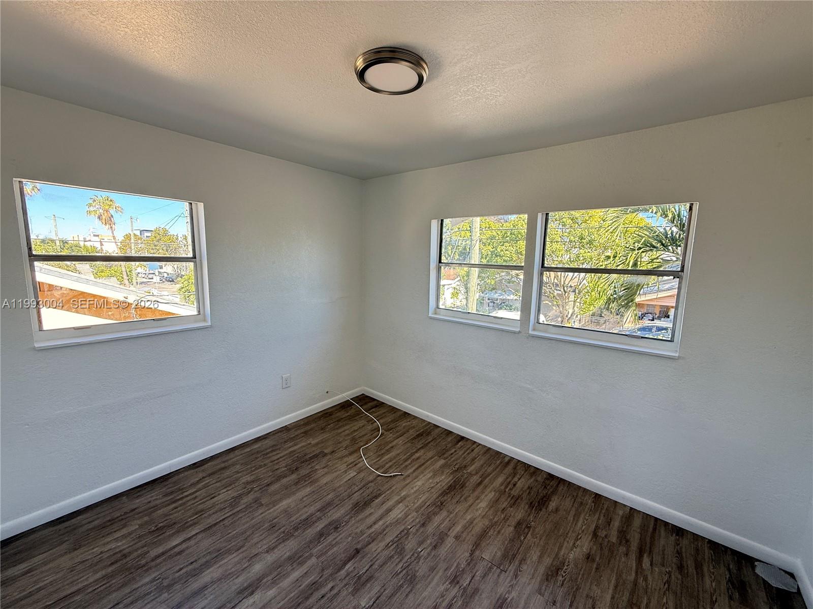 236 Southwest 10th Avenue, Unit B Miami, FL 33130 - Photo 3 of 11 a view of an empty room with wooden floor and window