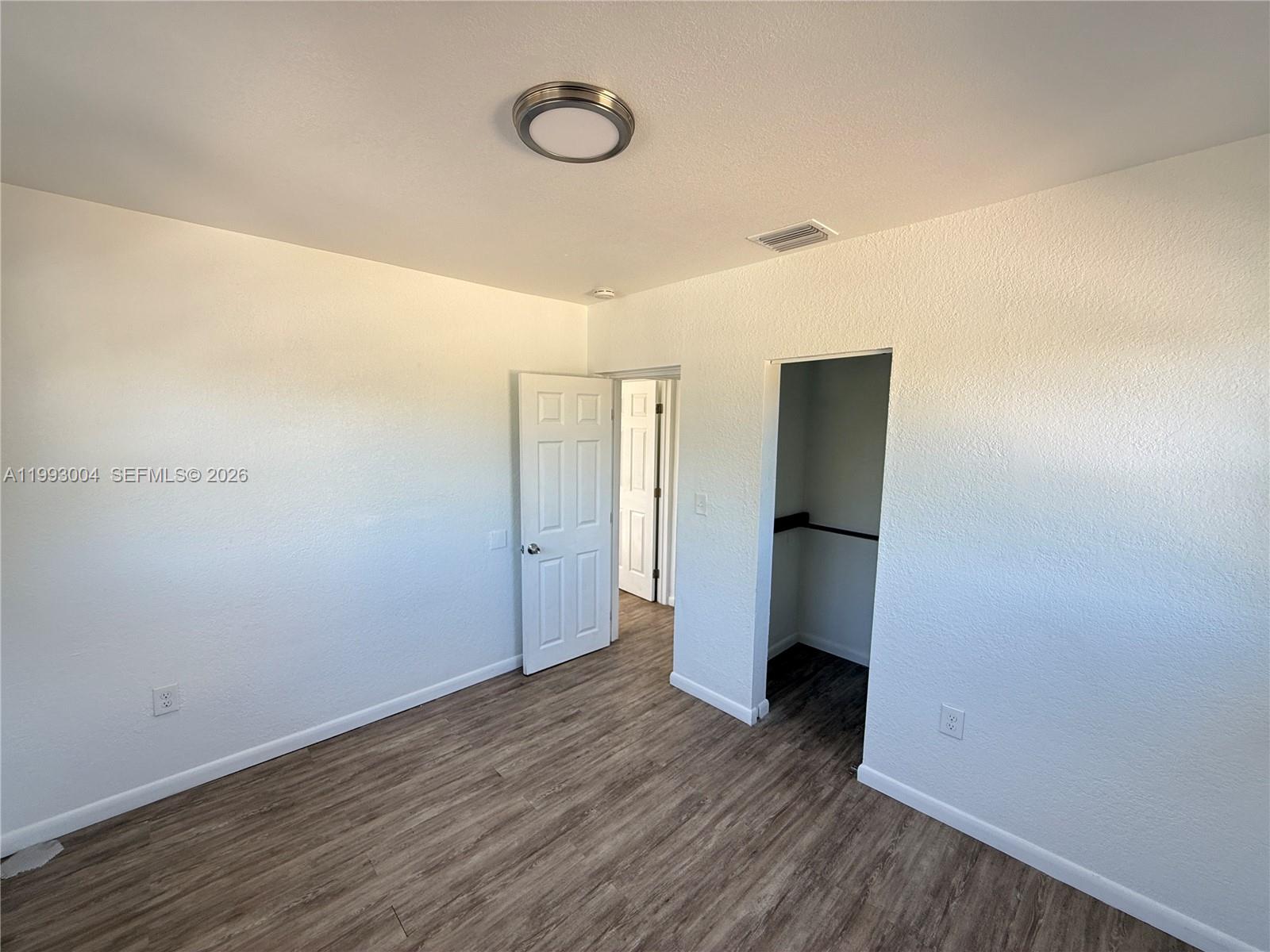 236 Southwest 10th Avenue, Unit B Miami, FL 33130 - Photo 6 of 11 a view of an empty room with wooden floor and closet
