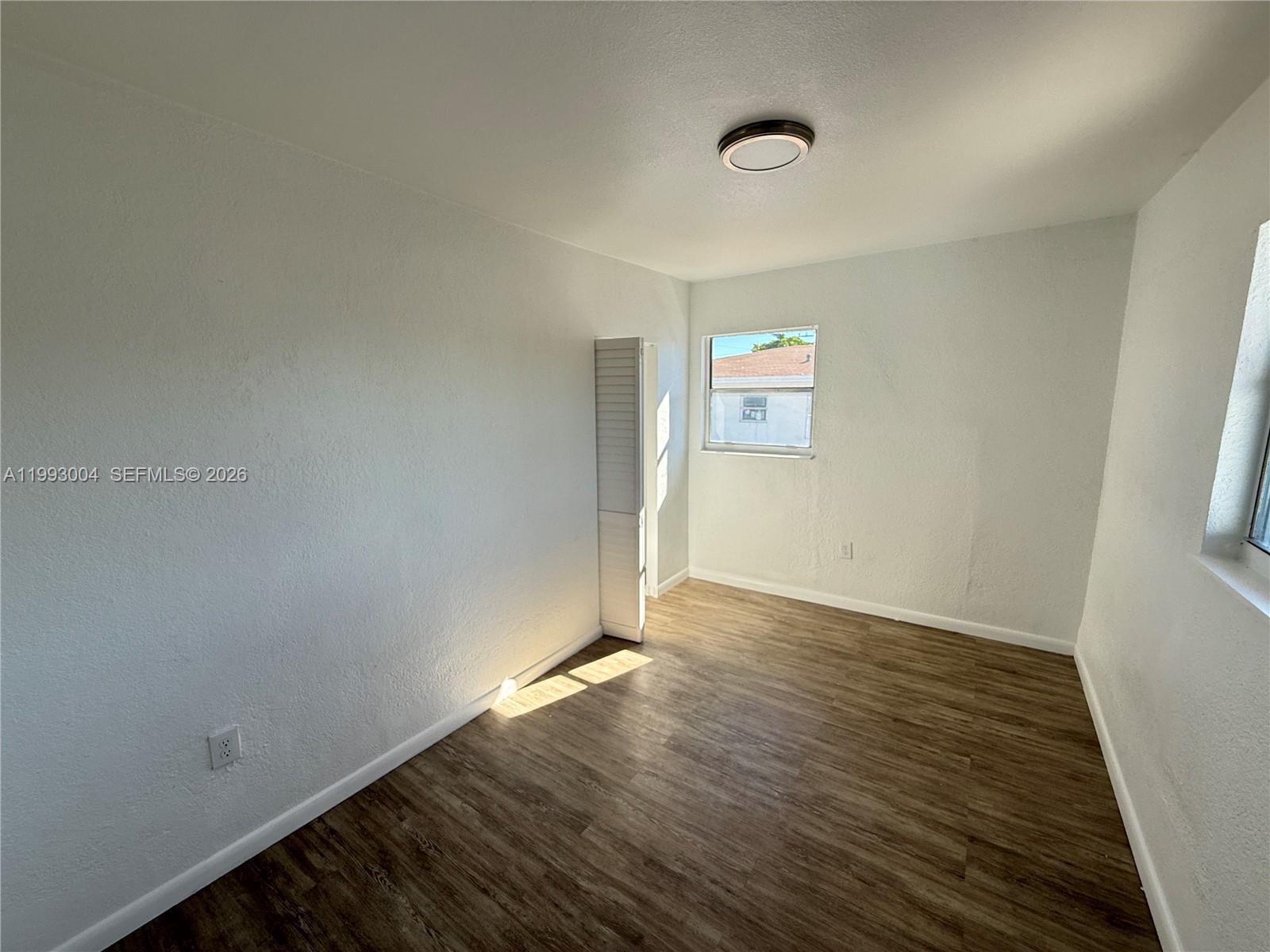 236 Southwest 10th Avenue, Unit B Miami, FL 33130 - Photo 7 of 11 an empty room with wooden floor and windows