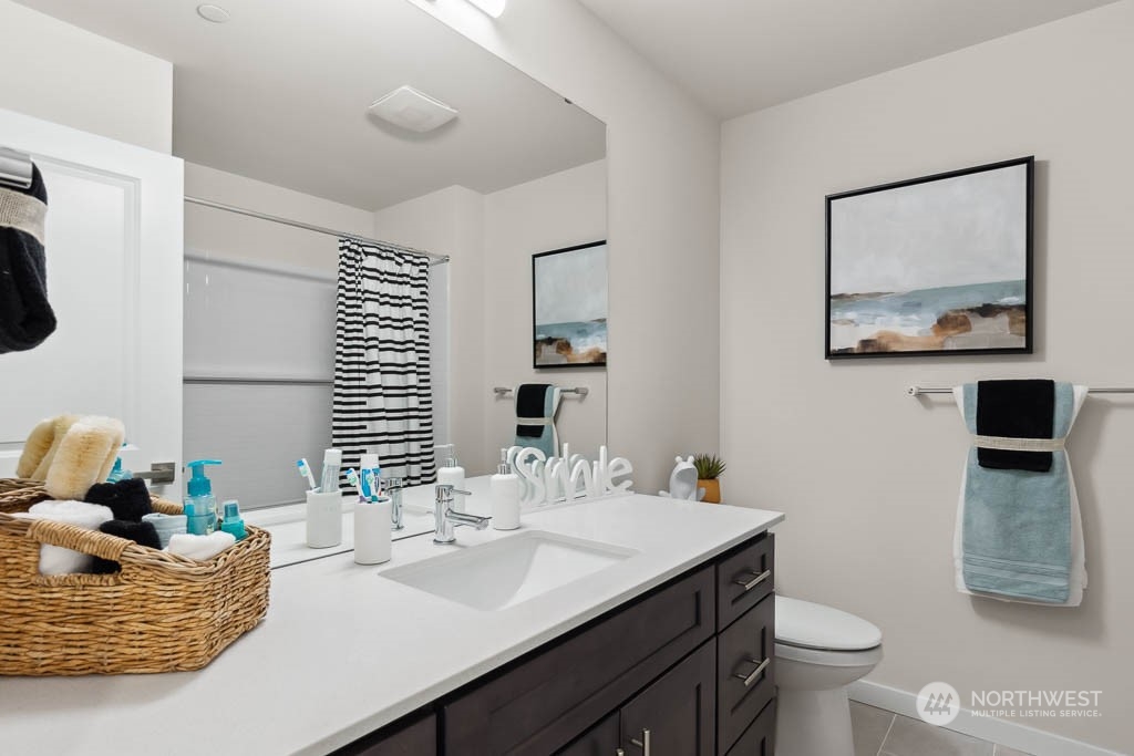 23413 Edmonds Way, Unit E2 Edmonds, WA 98026 - Photo 19 of 22 a bathroom with a granite countertop sink a toilet and mirror