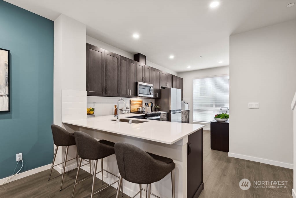 23413 Edmonds Way, Unit E2 Edmonds, WA 98026 - Photo 5 of 22 a kitchen with a stove a refrigerator and a dining table
