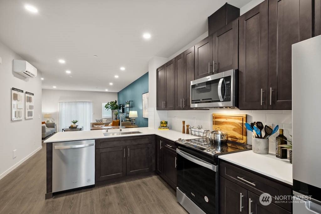 23413 Edmonds Way, Unit E2 Edmonds, WA 98026 - Photo 8 of 22 a kitchen with a sink a stove a microwave and wooden cabinets